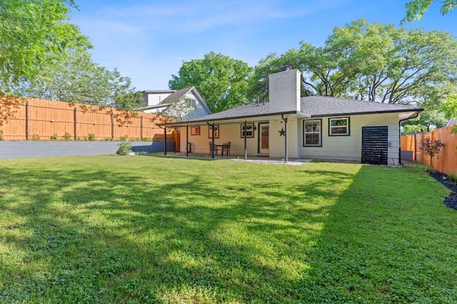 713 Buckingham Pl, Austin, TX 78745 - rear view of property featuring a fenced backyard, a patio, a chimney, and a lawn