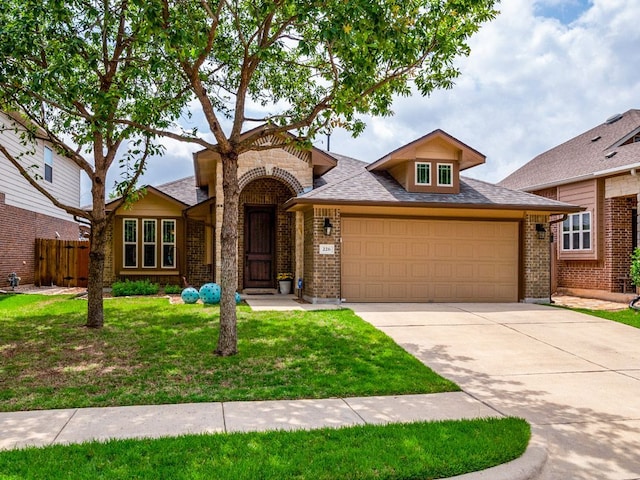 view of front facade featuring fence, an attached garage, brick siding, a front yard, and concrete driveway