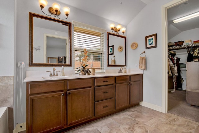 bathroom with a sink, vaulted ceiling, and double vanity