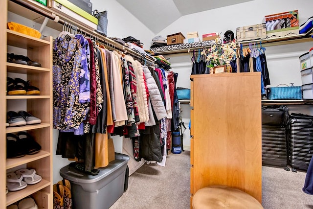 walk in closet featuring carpet and lofted ceiling