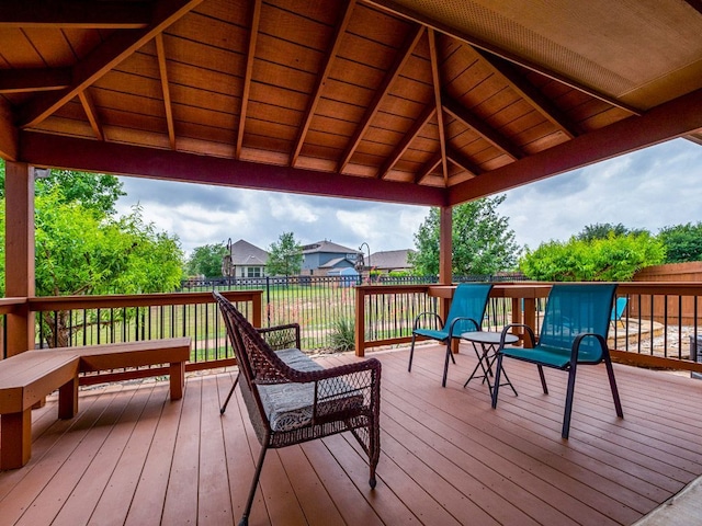 wooden terrace featuring a gazebo and fence