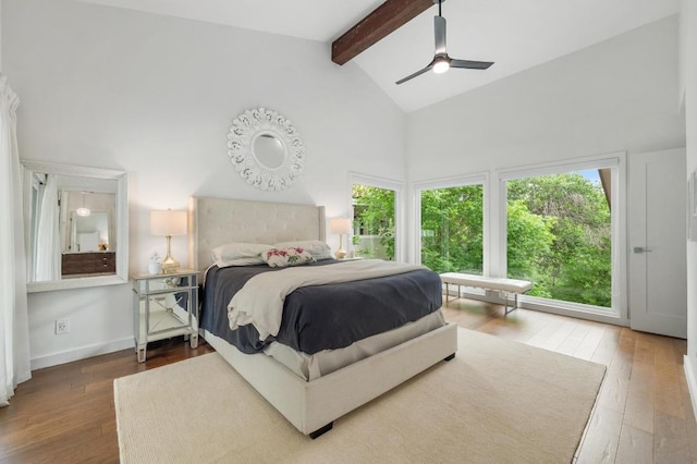 bedroom with high vaulted ceiling, multiple windows, hardwood / wood-style flooring, and beam ceiling