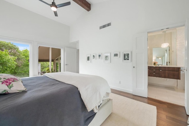 bedroom featuring ensuite bath, high vaulted ceiling, wood finished floors, beamed ceiling, and visible vents
