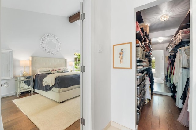bedroom with wood-type flooring, baseboards, and vaulted ceiling with beams