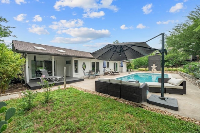 rear view of house featuring board and batten siding, outdoor lounge area, a patio area, and an outdoor pool