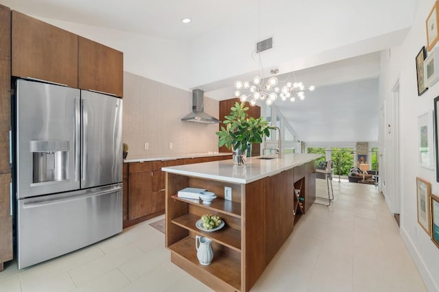 kitchen featuring open shelves, a sink, stainless steel fridge with ice dispenser, light countertops, and wall chimney exhaust hood