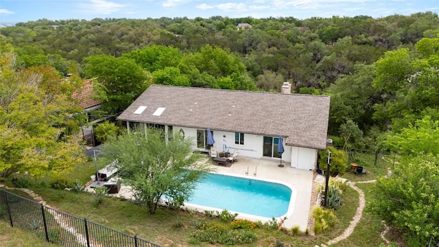 exterior space with a fenced backyard, a fenced in pool, a patio area, and a wooded view