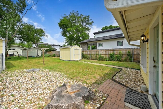 view of yard featuring a fenced backyard, a shed, and an outbuilding