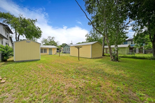 view of yard with a storage shed, fence, and an outbuilding