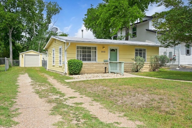 view of front facade featuring an outdoor structure, a garage, a front lawn, fence, and driveway