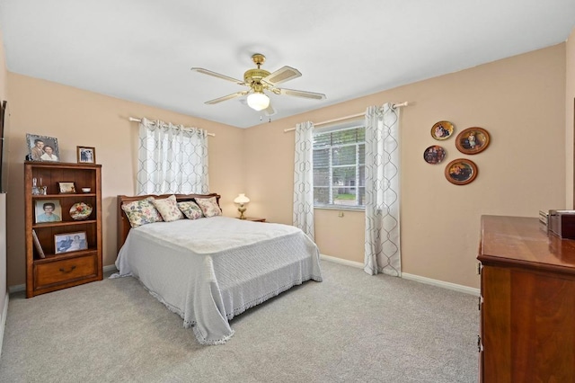 carpeted bedroom with a ceiling fan and baseboards