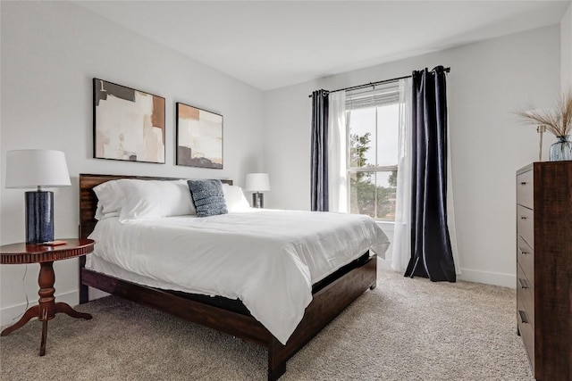 bedroom with baseboards and light carpet