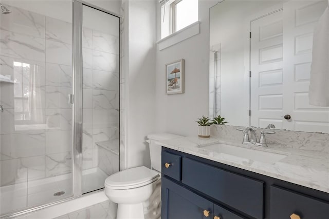 bathroom with vanity, toilet, marble finish floor, and a stall shower