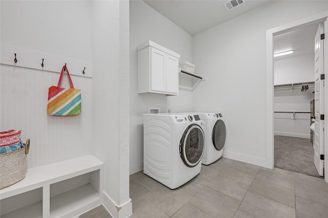 laundry room featuring visible vents, cabinet space, light tile patterned floors, baseboards, and washer and dryer