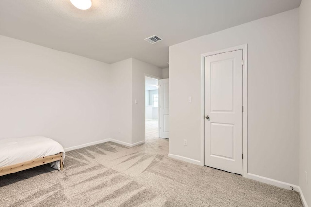 bedroom featuring visible vents, baseboards, and light colored carpet