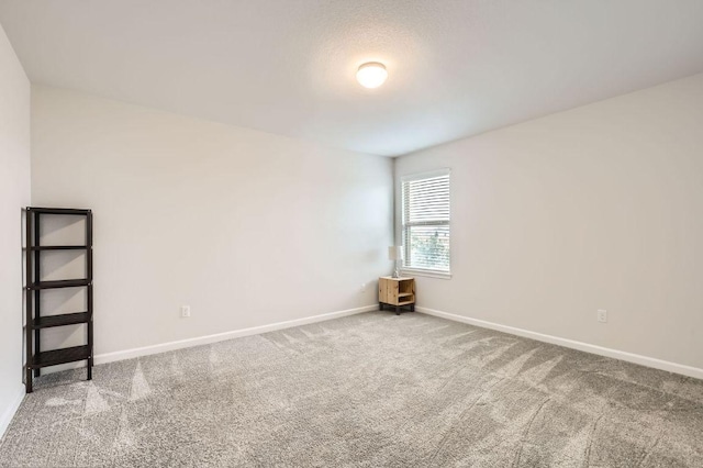 unfurnished room with baseboards and carpet flooring