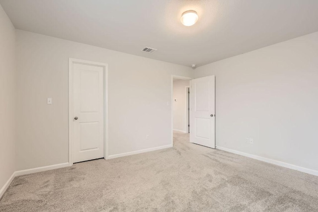 unfurnished bedroom featuring baseboards, carpet, and visible vents