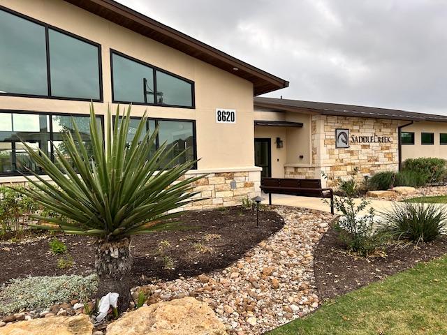 doorway to property featuring stone siding and stucco siding