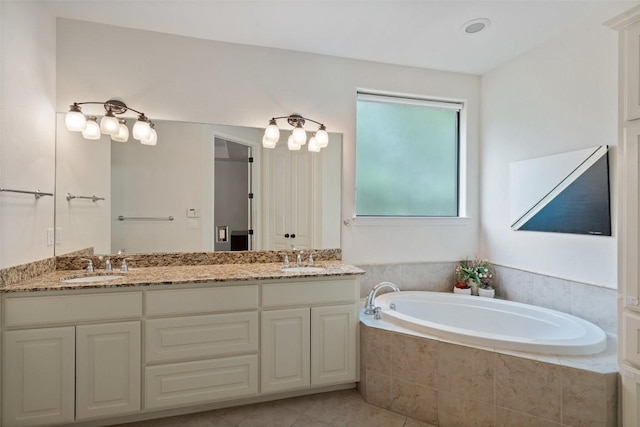 bathroom featuring double vanity, tile patterned floors, a sink, and a bath