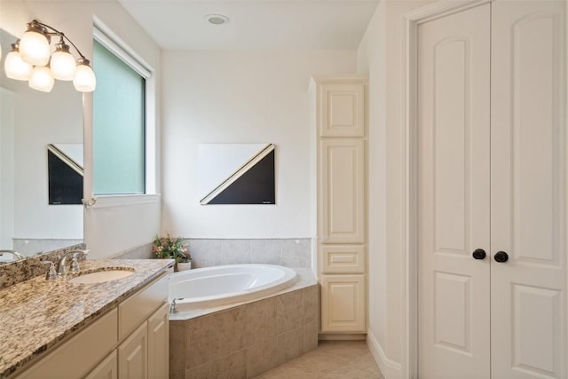 bathroom with tile patterned floors, a garden tub, and vanity