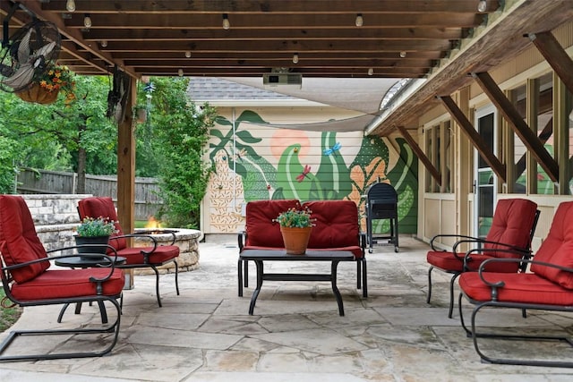 view of patio with an outdoor fire pit and fence