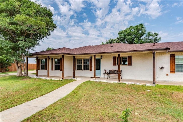 back of house with a lawn, fence, brick siding, and a patio