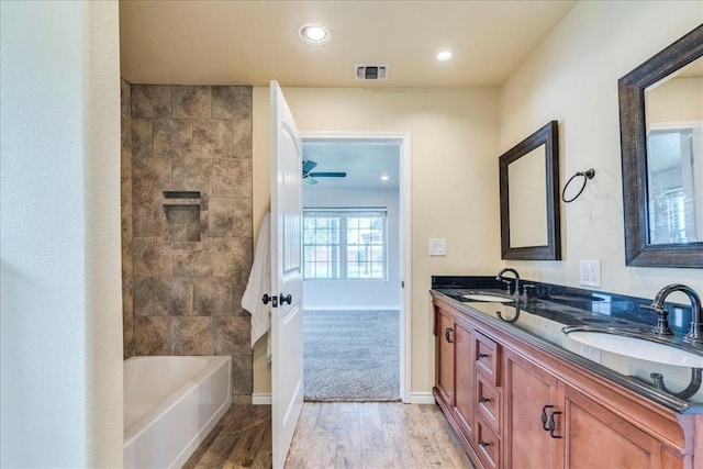 bathroom featuring visible vents, a sink, wood finished floors, and double vanity