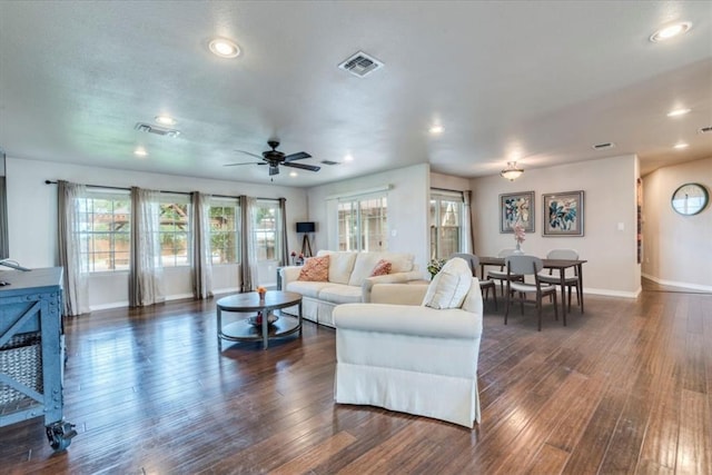 living area with baseboards, a wealth of natural light, and visible vents