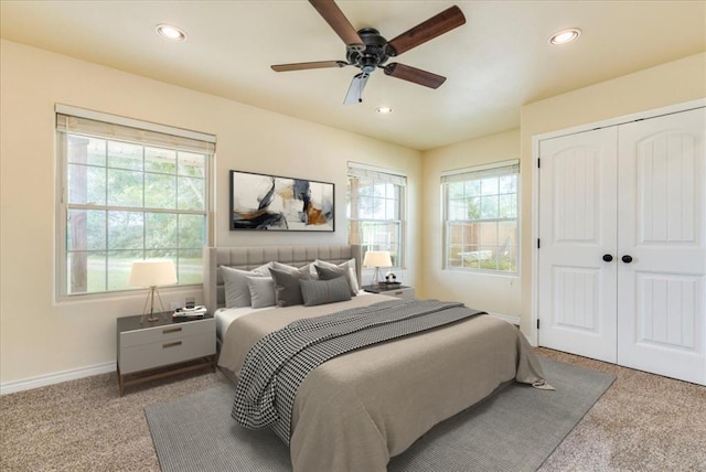 carpeted bedroom featuring recessed lighting, baseboards, multiple windows, and a closet