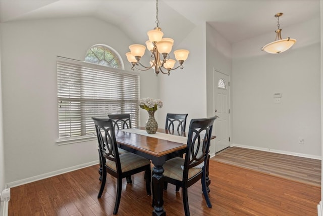 dining area featuring an inviting chandelier, baseboards, lofted ceiling, and wood finished floors
