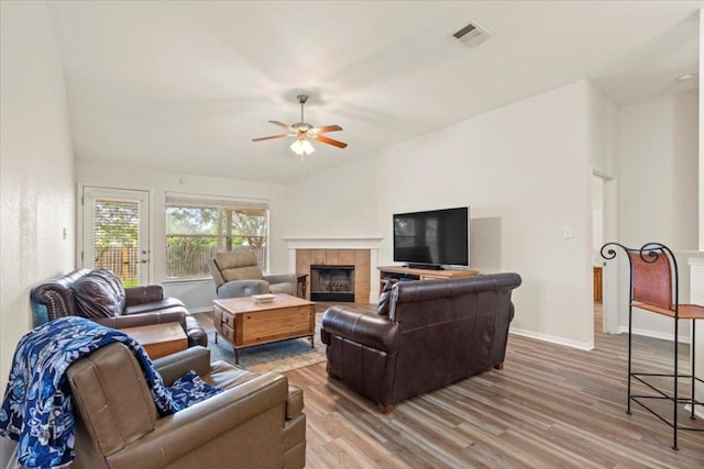 living area featuring baseboards, ceiling fan, light wood finished floors, and visible vents