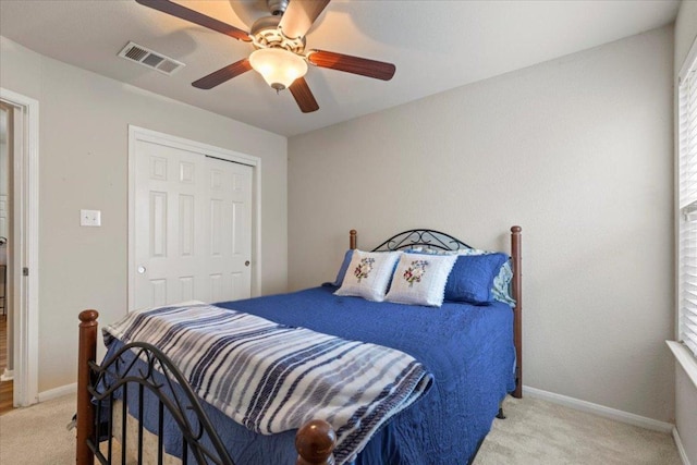 bedroom featuring baseboards, ceiling fan, light colored carpet, and visible vents