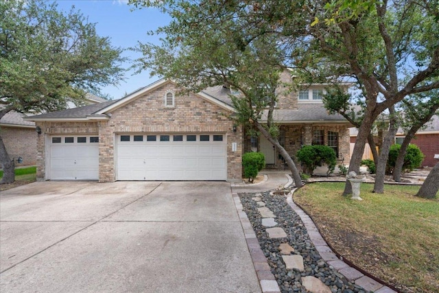 2302 Wheaton Trl, Cedar Park, TX 78613 - view of front of house with driveway, a garage, brick siding, and roof with shingles