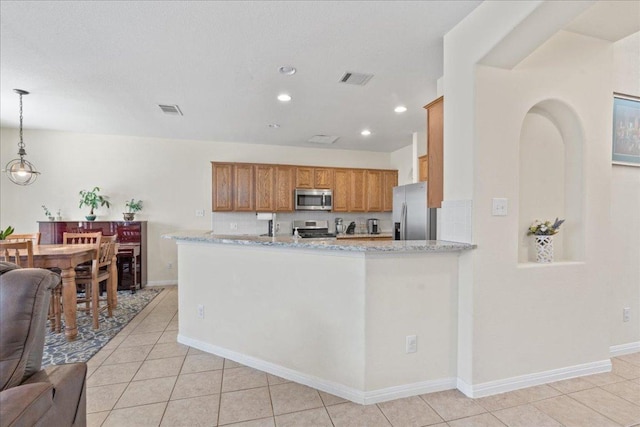 2302 Wheaton Trl, Cedar Park, TX 78613 - kitchen featuring stainless steel appliances, brown cabinets, light tile patterned floors, light stone counters, and recessed lighting