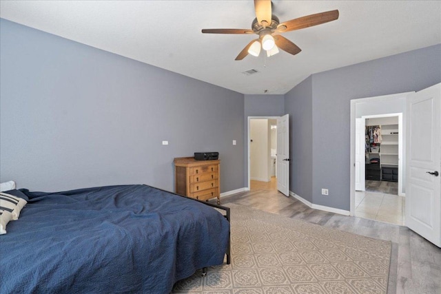 bedroom featuring visible vents, baseboards, ceiling fan, and wood finished floors