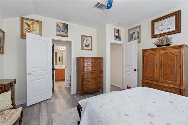 2302 Wheaton Trl, Cedar Park, TX 78613 - bedroom with wood finished floors, baseboards, vaulted ceiling, a ceiling fan, and connected bathroom