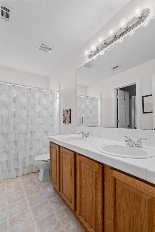 2302 Wheaton Trl, Cedar Park, TX 78613 - full bathroom with double vanity and tile patterned flooring