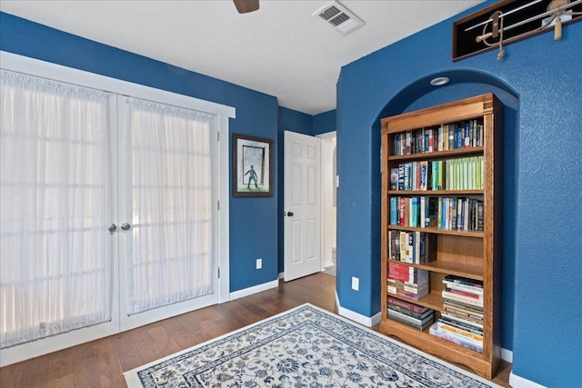 interior space featuring baseboards, wood finished floors, and visible vents
