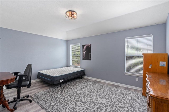 bedroom featuring baseboards and wood finished floors