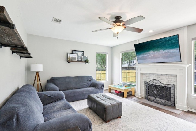 living room with ceiling fan, a fireplace, recessed lighting, wood finished floors, and visible vents
