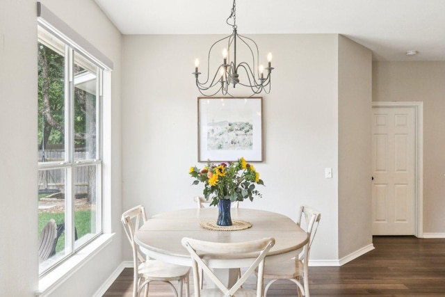 dining area featuring baseboards, a chandelier, and dark wood-type flooring