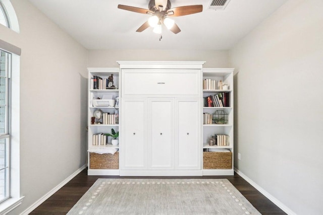unfurnished bedroom with a ceiling fan, baseboards, dark wood finished floors, and visible vents