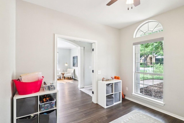 entryway featuring dark wood-style flooring, ceiling fan, baseboards, and arched walkways
