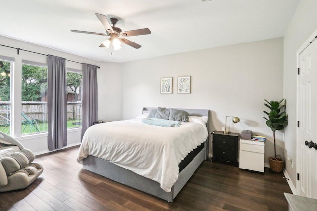 bedroom with baseboards, a ceiling fan, and dark wood-style flooring