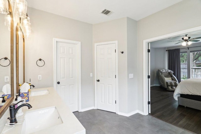 ensuite bathroom with ceiling fan, visible vents, a sink, and ensuite bath