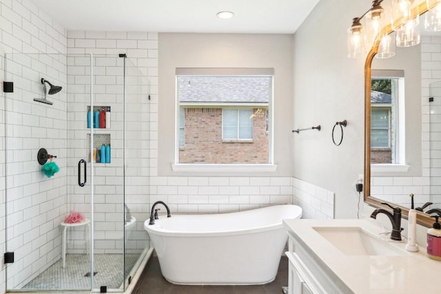 bathroom featuring tile walls, a shower stall, a soaking tub, and vanity