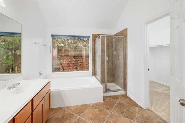 full bath featuring a bath, vaulted ceiling, a spacious closet, and a shower stall