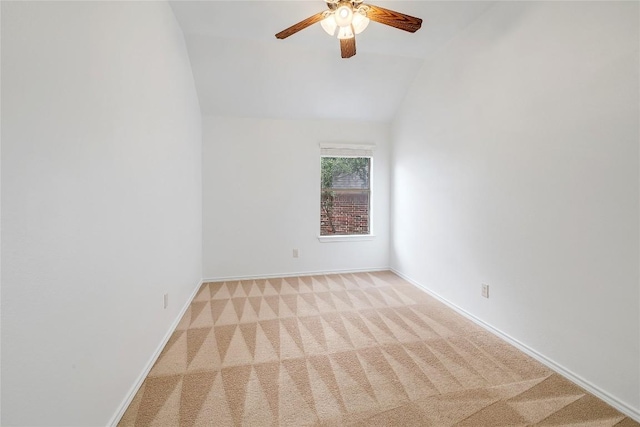 carpeted empty room with baseboards, ceiling fan, and vaulted ceiling
