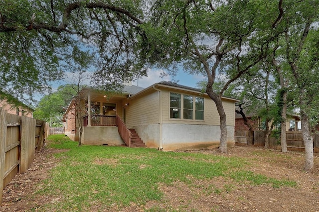 back of house with a yard and a fenced backyard