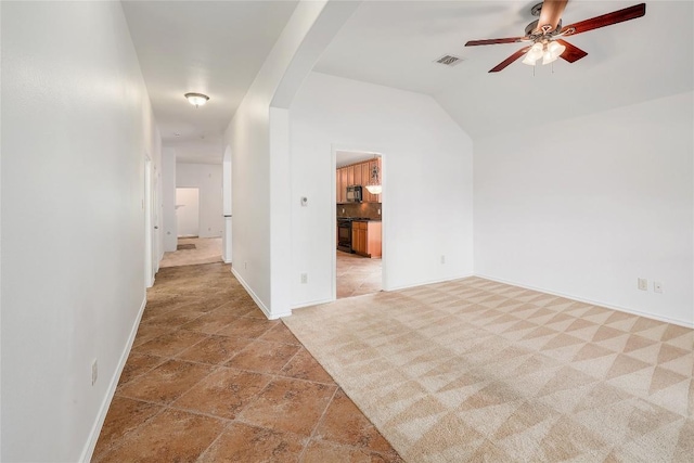 spare room featuring arched walkways, a ceiling fan, baseboards, lofted ceiling, and visible vents